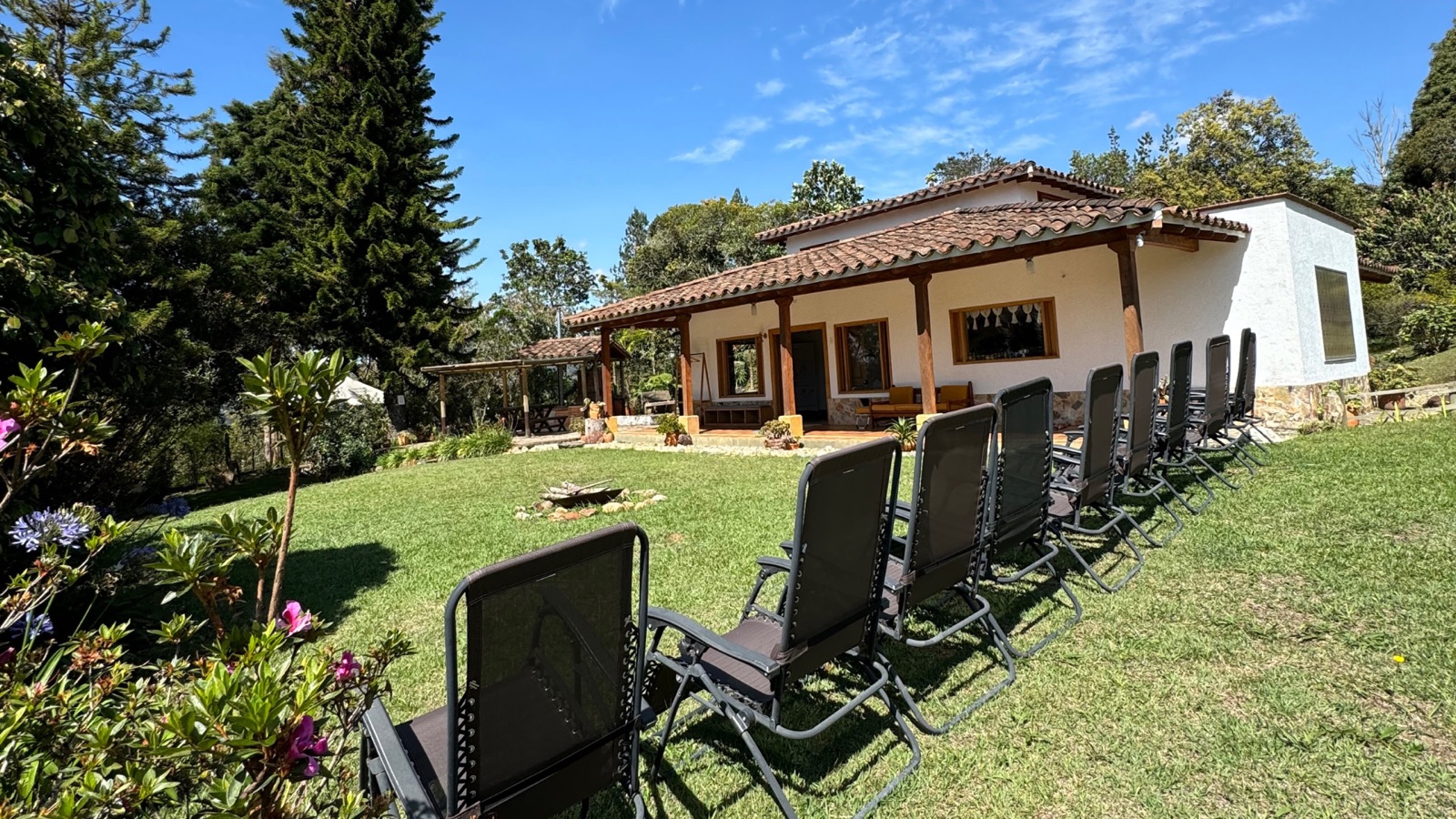 Jard&iacute;n de la sede de Guarne, con sillas dispuestas frente a la casa