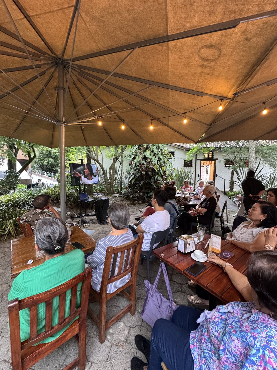 Grupo pequeño conversando en un Café con la Muerte al aire libre